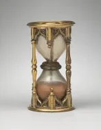 An antique hourglass in a gilt frame