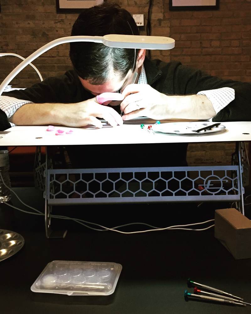A student works at a portable HSNY watchmaking bench inside a boutique