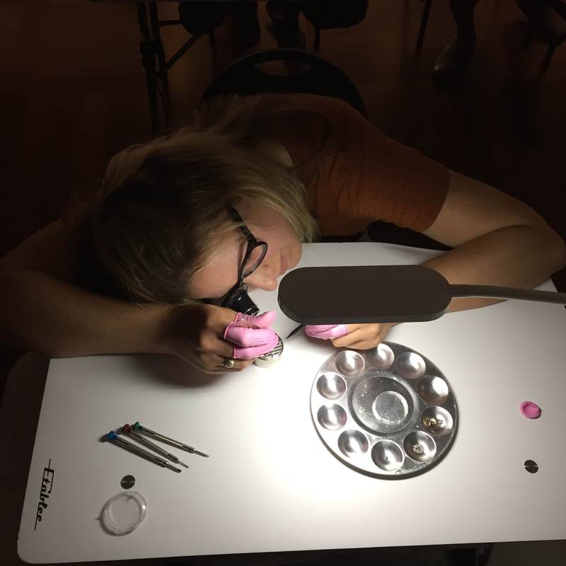 Overhead view of a student working at a white bench under a lamp