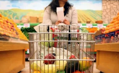 A shopper pushing a trolley in a supermarket